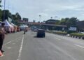 Anggota Pramuka membantu pejalan kaki menyeberang jalan di kawasan Pos Gadog Puncak Bogor.