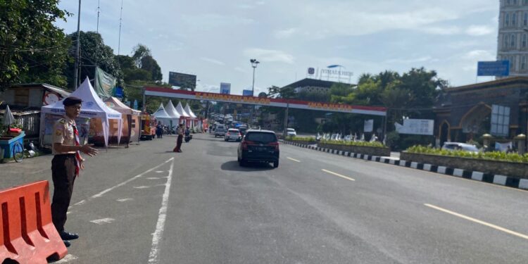 Anggota Pramuka membantu pejalan kaki menyeberang jalan di kawasan Pos Gadog Puncak Bogor.