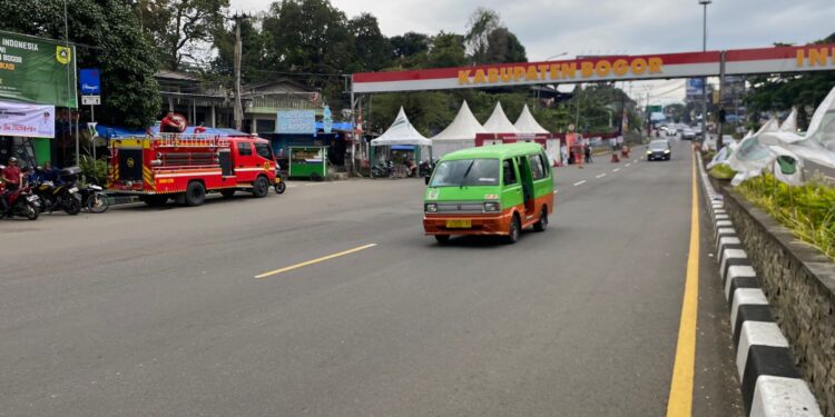 Potret angkutan kota (angkot) yang masih melintas di jalur Puncak Bogor meskipun ada larangan operasional.