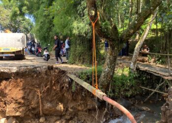 Kondisi jembatan alternatif Summarecon menuju Gadog di Desa Pasir Angin yang putus akibat pondasi terkikis banjir