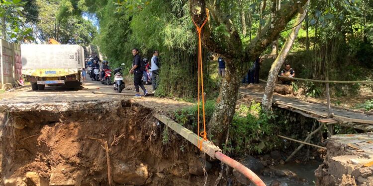 Kondisi jembatan alternatif Summarecon menuju Gadog di Desa Pasir Angin yang putus akibat pondasi terkikis banjir