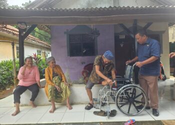 Kepala Desa Nagrak Agus Syahrudin saat menerima/menyerahkan bantuan kursi roda dari Dinas Sosial Kabupaten Bogor.