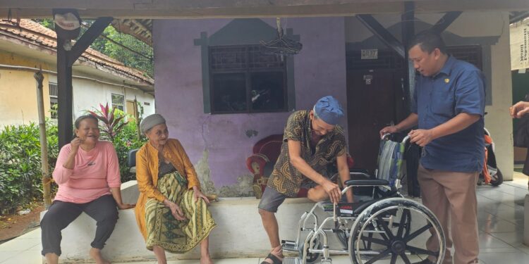 Kepala Desa Nagrak Agus Syahrudin saat menerima/menyerahkan bantuan kursi roda dari Dinas Sosial Kabupaten Bogor.
