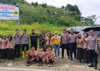 Petugas kepolisian dan relawan membantu pengendara di Tanjakan 2000 Sukamakmur Kabupaten Bogor.