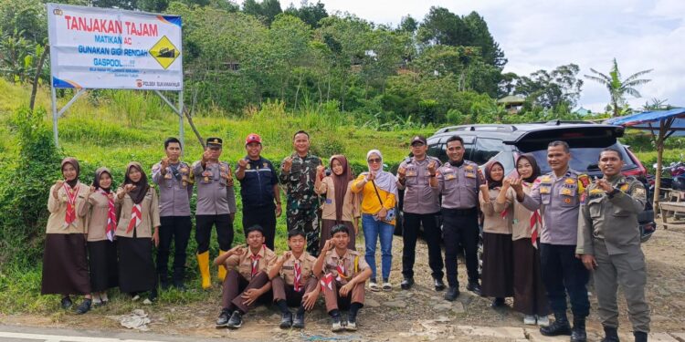 Petugas kepolisian dan relawan membantu pengendara di Tanjakan 2000 Sukamakmur Kabupaten Bogor.