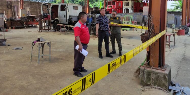 Petugas Satpol PP Kabupaten Bogor saat memasang segel dan garis PPNS di gerbang PT Kajama Gunung Putri.